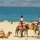 Photo de touristes faisant une balade à dos de dromadaire sur la plage près de Tanger