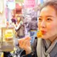 Photo d'une femme dégustant de la nourriture chinoise dans les rues d'Hong Kong