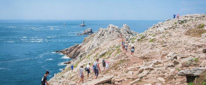 Admirez les randonneurs explorant la Pointe du Raz, trouvez un billet d'avion pas cher pour Quimper 